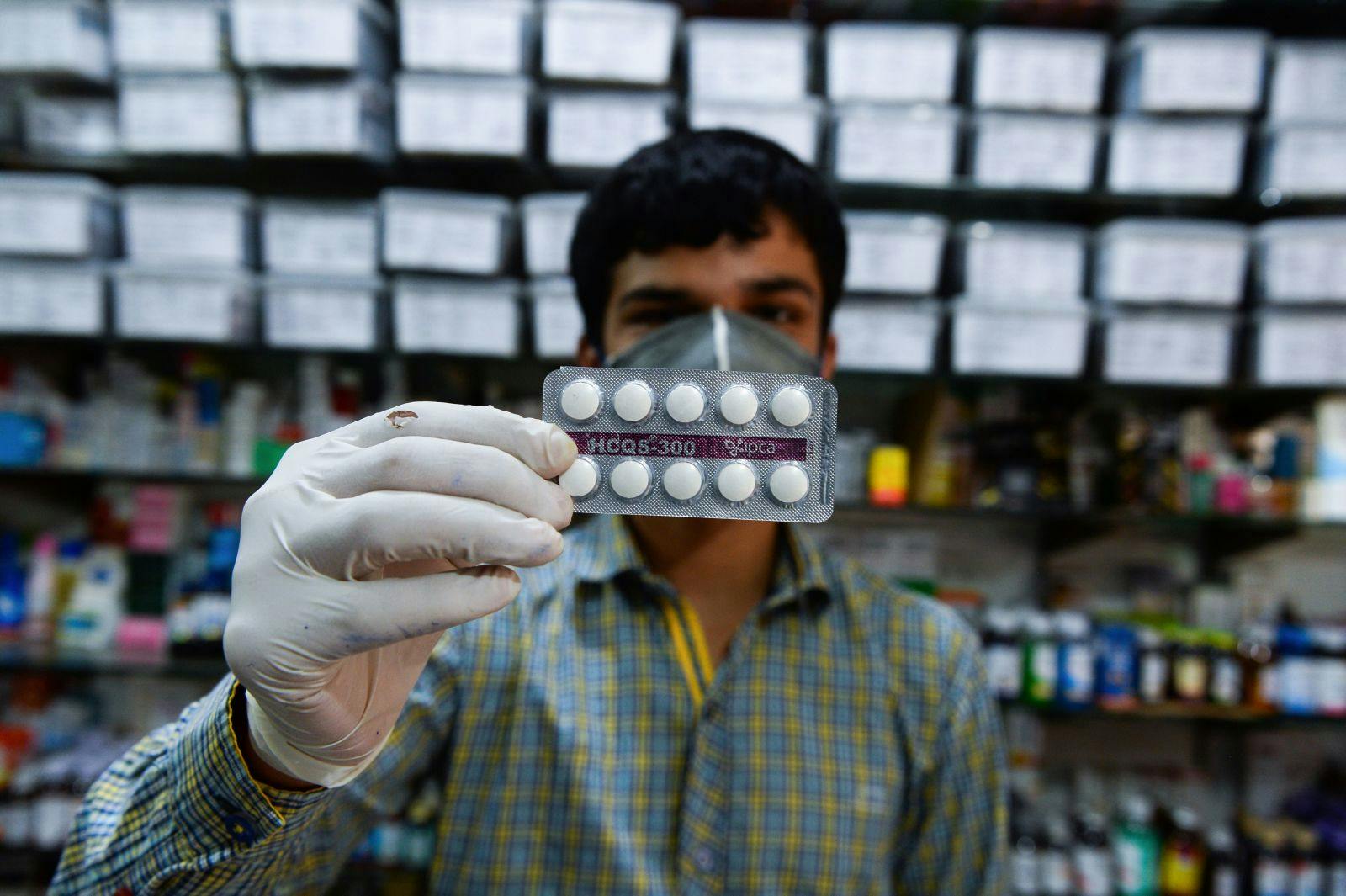 Pharmacy employee displaying hydroxychloroquine (HCQ) tablets in his store in New Delhi on April 27, 2020 (SAJJAD HUSSAIN/AFP via Getty Images)
