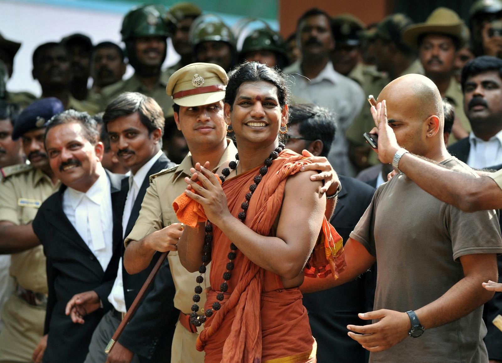 Police escort Swami Nityananda (C) after appearing for his bail plea at the judicial magistrate court at Ramanagar District, some 50 kms from Bangalore, on June 14, 2012. Police ordered Swami Nithyananda, 35, to be detained for questioning after five women accused him of abusing them at his ashram in Karnataka. (Manjunath Kiran/AFP/Getty Images)