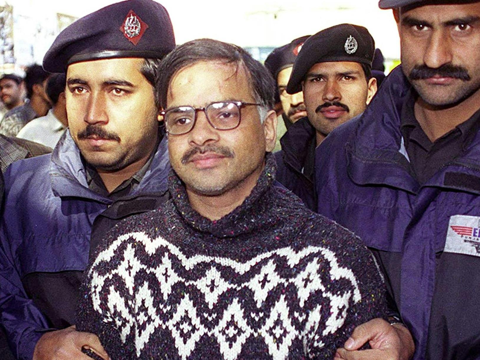 Picture dated 17 February 2000 shows alleged serial killer, Javed Iqbal (C) arriving in court under police custody in Lahore, Pakistan (ARIF ALI/AFP via Getty Images)
