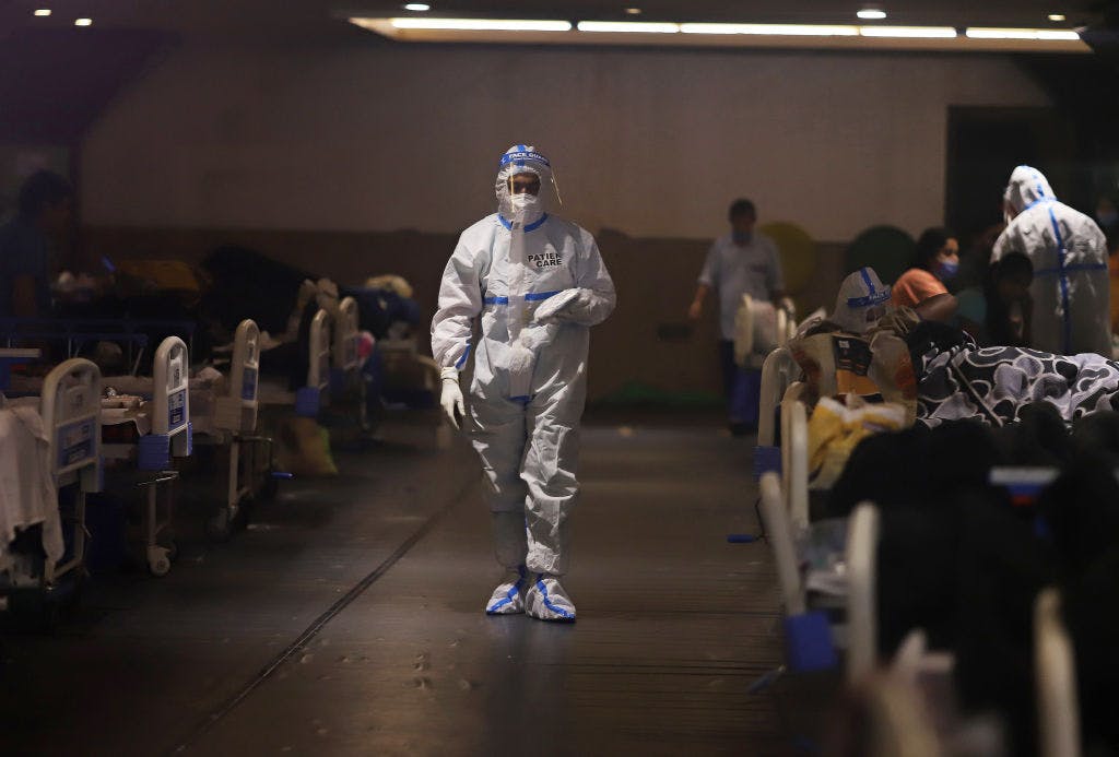 A health worker walks through at a makeshift COVID-19 quarantine facility set up at a banquet hall in New Delhi, India, on Wednesday, April 21, 2021 (Anindito Mukherjee/Bloomberg via Getty Images)
