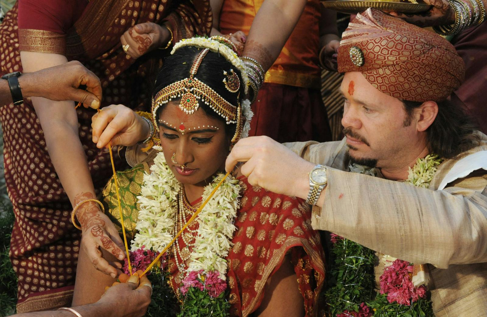 Scott Higgins ties the mangalsutra around the neck of bride Nayanatara Nanda Kumar (NOAH SEELAM/AFP via Getty Images)
