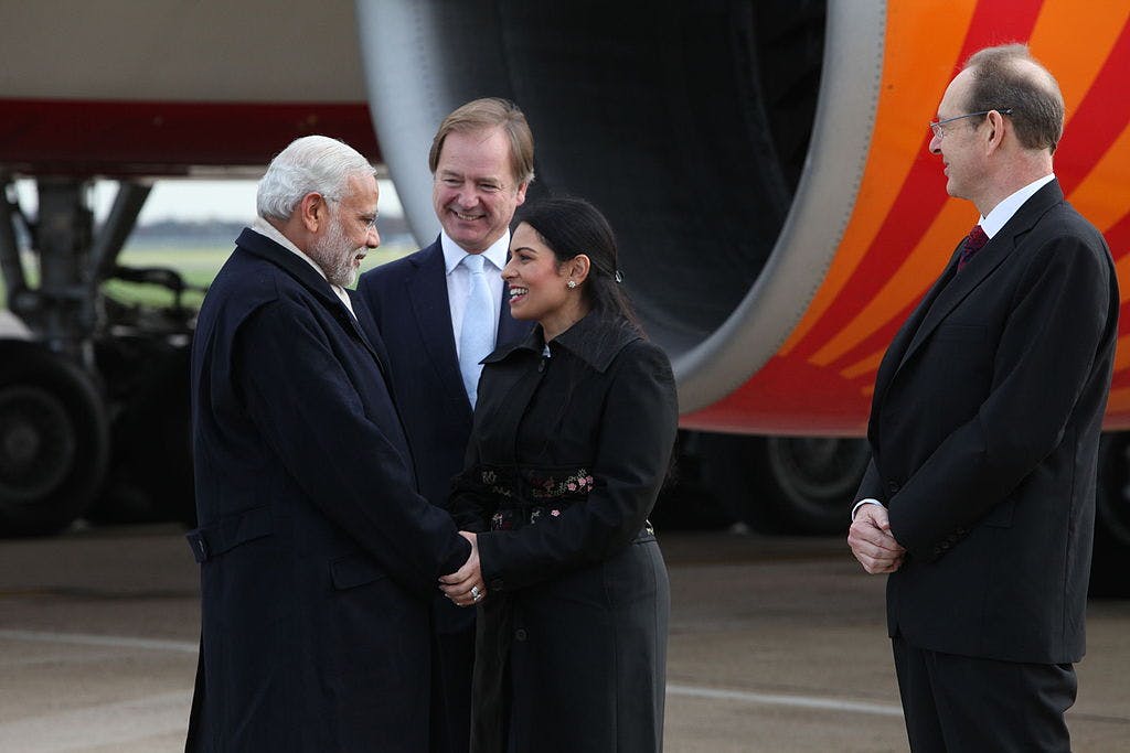Narendra Modi is greeted by British MP Priti Patel after arriving at Heathrow Airport (Wikimedia)
