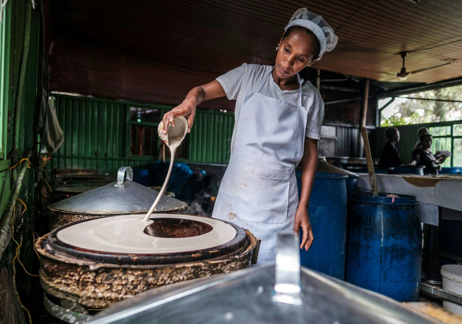 A woman prepares injera, a sour fermented flatbread with a slightly spongy texture, in a bakery in Addis Ababa, on June 12, 2021 (EDUARDO SOTERAS/AFP via Getty Images)