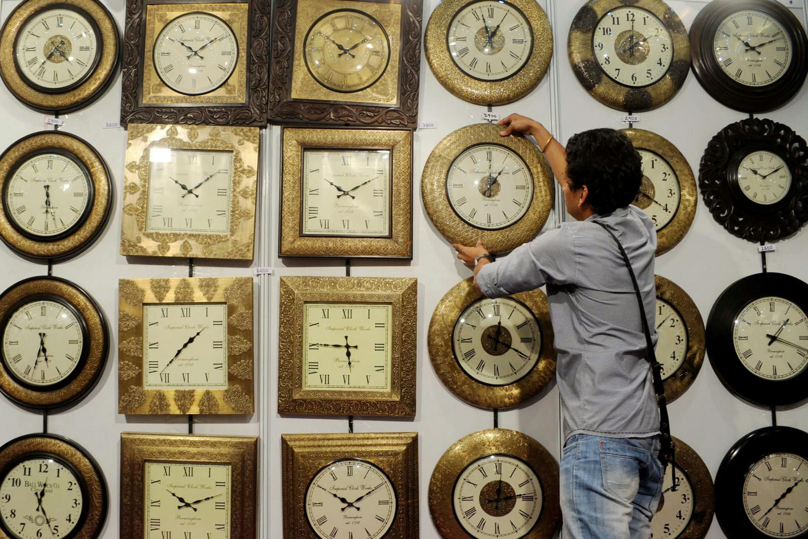 Indian exhibitor Hardik arranges a display of wooden clocks at a stall during an exhibit in Amritsar on September 7, 2012 (NARINDER NANU/AFP/Getty Images)