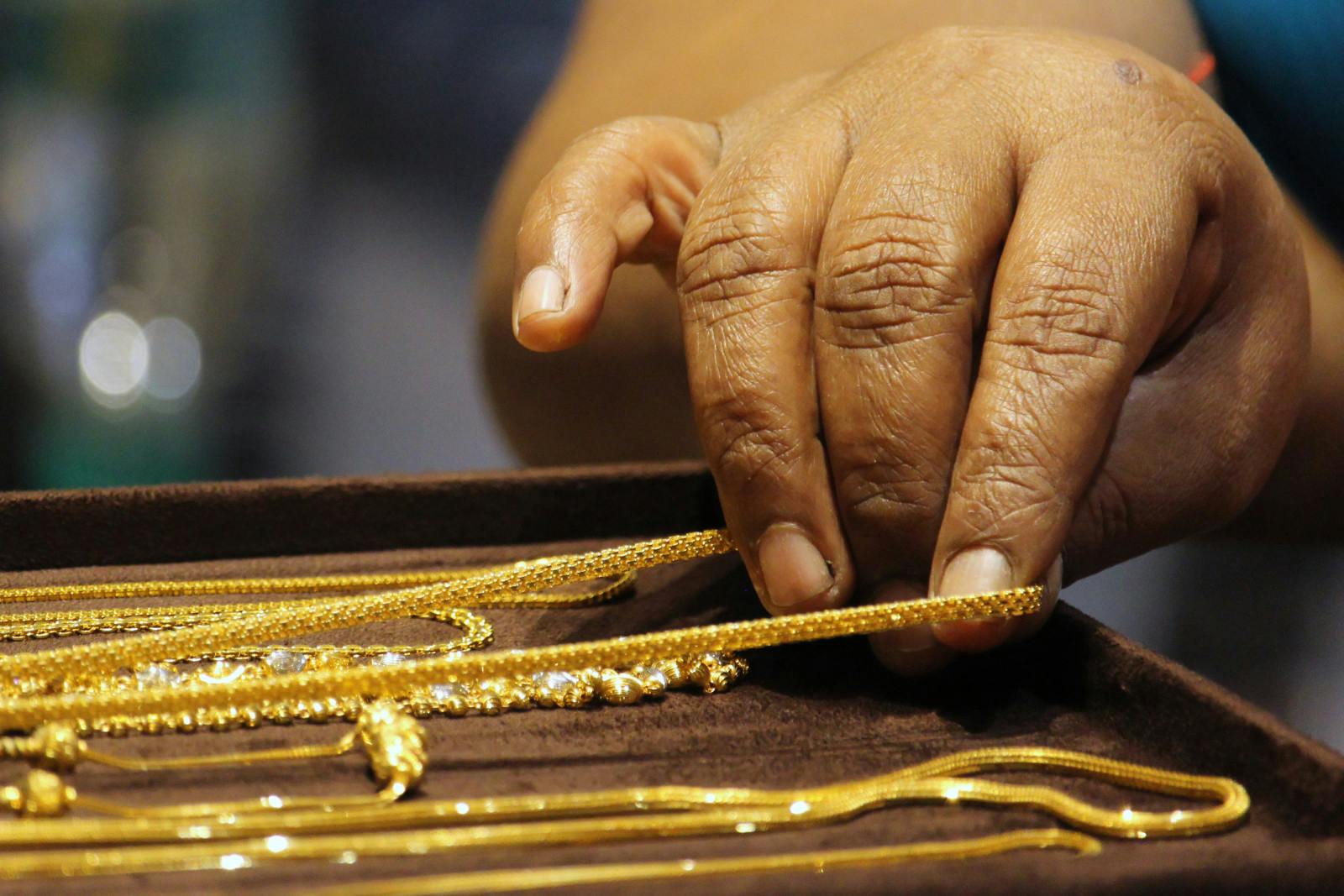 A customer holds gold ornaments during the launch of a showroom in Mumbai, India in 2019 (Himanshu Bhatt/NurPhoto via Getty Images)