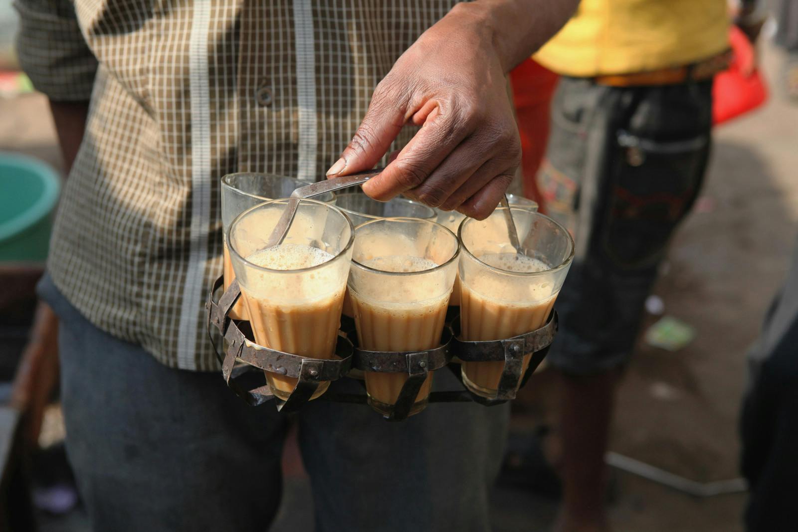 A chai vendor carrying glasses of tea in Delhi, India (Eye Ubiquitous/Universal Images Group via Getty Images)