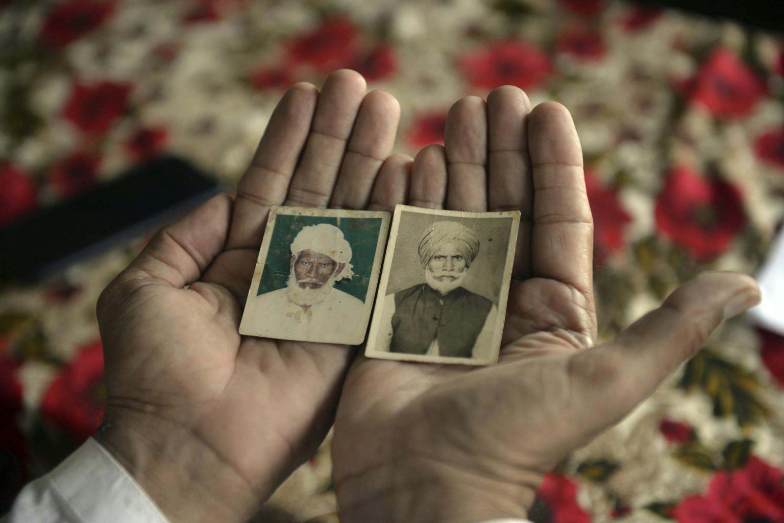 Shahbaz Khan shows pictures of his uncle Inayat Khan (left), who was also separated from the family at the time of Partition and died in India a few years ago, and his late father Sharif Khan (Murtaza Ali/picture-alliance/dpa/AP Images)