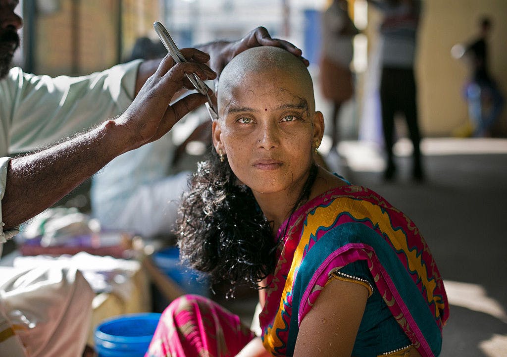 28-year-old Rupa has her hair shaved to donate at the Thiruthani Murugan Temple November 10, 2016 in Thiruttani, India (Photo by Allison Joyce/Getty Images).